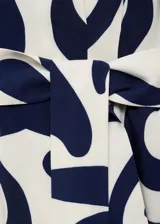 Vestido camisero midi con estampado abstracto en tonos azul y blanco. Tiene cuello camisero, cierre frontal con botones, cinturón desmontable y corte sin mangas.
