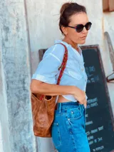 Bolso tote de cuero color marrón con asas trenzadas en marrón y rojo.