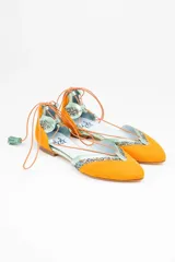 Bailarinas color naranja con detalles en celeste y glitter. Cuentan con cordones de algodón con borlas de ante, cuña interna de 1,5cm y suela de cuero. Incluyen plantilla de piel y plantilla extra de lana intercambiable.
