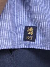 Camisa verde militar de manga larga, confeccionada en mezcla de lino y algodón. Tiene cuello clásico, cierre con botones y un bolsillo en el pecho.