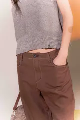 Pantalón marrón de lino rústico, con calce recto y tiro medio. Tiene bolsillos delanteros y traseros.