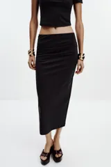 Falda midi color crema, de tiro alto con cintura elástica y detalle de pliegues laterales.