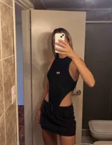 Body negro de lycra con cuello alto, corte cavado y logo metálico en el pecho.