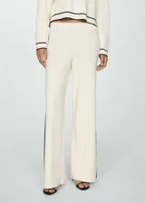 Pantalón palazzo color crudo de punto fino con cintura elástica y bandas laterales negras en contraste.