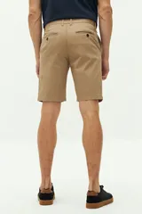 Bermuda de gabardina azul marino con logo bordado, bolsillos laterales y traseros, cierre con cremallera y botón, y presillas para cinturón.