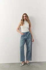 Musculosa negra de tejido de punto acanalado, con cuello alto y corte ajustado.