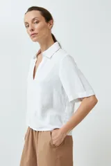 Blusa blanca de lino con cuello camisero y mangas cortas.