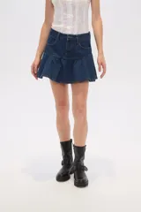 Minifalda negra de jean con diseño acampanado y volantes en el dobladillo.