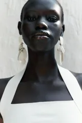 Aros colgantes con múltiples piezas de resina color crema, blanco y gris. Cierre con tuerca.