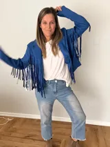 Campera de gamuza sintética color azul con flecos largos en mangas y espalda, corte recto con solapas clásicas.