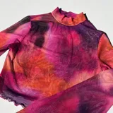 Top de malla traslúcida con cuello alto y mangas largas, con estampado abstracto en tonos fucsia, naranja y violeta.