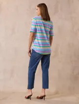 Remera de algodón a rayas horizontales en tonos rosa, celeste, verde y lila. Tiene cuello redondo y mangas cortas con detalle de entrelazado y aberturas en los hombros.