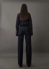 Pantalón de jean azul oscuro de corte recto, tiro alto y cinco bolsillos.