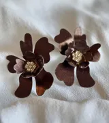 Par de aros con forma de flor color lila con centro de strass plateado.