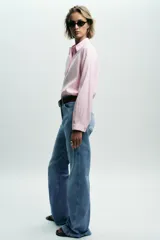 Camisa rosa de cuello solapa y manga larga. Tejido suave. Cierre frontal con botones a tono.