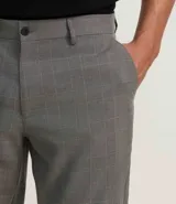 Pantalón de vestir gris con estampado de cuadros en hilo teñido, corte slim, cintura con trabillas, cierre con botón y cremallera.