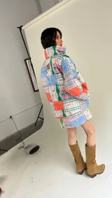 Campera puffer con estampado patchwork multicolor, cuello alto y bolsillos laterales.