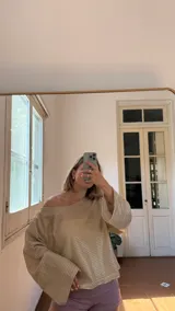 Blusa de manga larga con escote bote, confeccionada en tejido metalizado dorado suave.