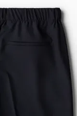 Pantalón de vestir negro de corte recto con cintura elástica y cordón ajustable. Tiene bolsillos laterales y traseros.