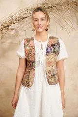 Chaleco abierto con diseño patchwork multicolor y ribete blanco.