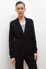 Ruana de tejido de punto color marrón chocolate, con cuello redondo y mangas largas.