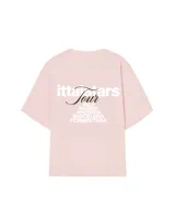 Remera rosa de corte recto con estampado en la espalda que incluye el texto "Itta Tours", "Tour", y nombres de ciudades como Ibiza, Madrid, Andorra, Barcelona y Formentera.