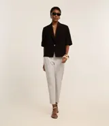 Pantalón carrot de sastrería de cintura alta color azul marino, con trabillas y bolsillos delanteros.