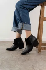 Bota corta de cuero color marrón con paneles de gamuza y cuero texturizado.