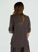 Blusa azul marino de corte recto, cuello redondo y mangas cortas con volados.