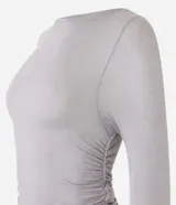 Blusa de viscosa color gris con efecto gastado, cuello redondo, mangas largas, fruncido lateral y abertura.