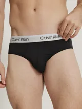 Pack de 3 slips Calvin Klein de corte clásico, confeccionados en tejido micro stretch de poliéster y elastano. Incluye tres slips negros con cinturas elásticas de diferentes colores: gris, dorado y blanco, con el logo de la marca.