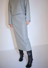 Falda midi gris de felpa con cintura elástica y abertura posterior.