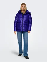Campera puffer azul eléctrico con capucha, cierre frontal con cremallera, bolsillos laterales con solapa y puños con elástico. Diseño acolchado y corte holgado.
