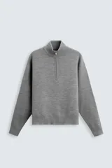 Sweater gris de punto con cuello alto y cierre de cremallera frontal.