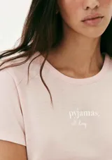 Pijama de dos piezas compuesto por una remera de manga corta color crema con un pequeño bordado de concha marina y un short de tiro alto con elástico y estampado de cuadrícula en tonos beige y blanco.