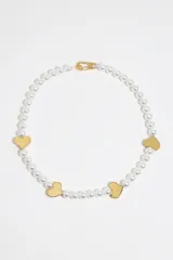 Collar corto de perlas con detalles en forma de corazón y cierre de mosquetón.
