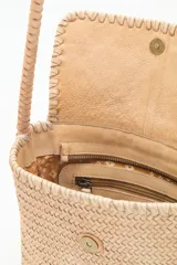 Cartera bandolera negra de cuero vacuno trenzado, con acceso superior con cierre metálico, interior forrado con bolsillos y correa de hombro trenzada.