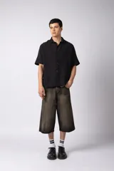 Camisa negra de lino con cuello clásico, manga corta y cierre frontal con botones.