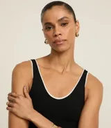 Musculosa blanca de rib de viscosa con breteles medianos, escote en U y detalle de bies contrastante en negro.