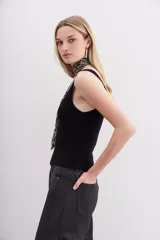 Musculosa negra ajustada al cuerpo, con escote pronunciado y tejido de punto compacto.