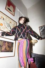 Sweater de punto negro con cuello alto y diseño de rombos de colores bordados.