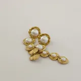 Aros colgantes largos dorados con cinco perlas de imitación de diferentes tamaños. Cierre con tuerca a presión.