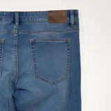Jean slim de corte elástico, color azul, diseño clásico de cinco bolsillos.