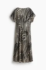 Vestido largo de punto con textura, estampado con motivos de hojas en blanco y negro. Tiene mangas cortas amplias, escote redondo y cintura entallada con pliegues.