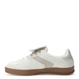 Zapatillas deportivas acordonadas color beige con suela marrón.