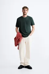 Jersey de punto color marrón oscuro, de corte relajado (relaxed fit), con cuello redondo y manga corta.