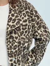 Campera color marrón claro con cuello solapa, cierre frontal con botones y bolsillos con solapa en el pecho.