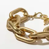 Pulsera dorada de eslabones grandes con cierre de mosquetón.