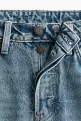 Pollera larga de denim azul, de tiro alto, con cinco bolsillos, cierre de botones y silueta levemente evasé. Presenta nesgas adelante y atrás.
