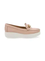Mocasín de cuero charol negro con plataforma blanca y detalle de hebilla metálica plateada en el empeine.